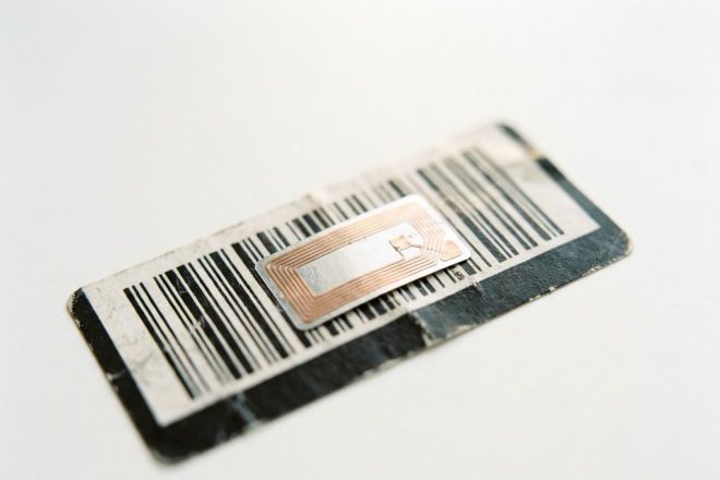 RFID-chip met metalen antennecircuits op zwart-wit streepjescode label tegen witte achtergrond