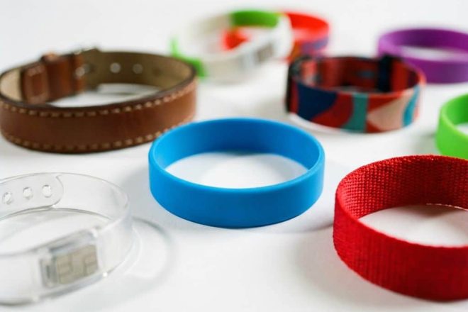 Verschillende RFID-polsbandjes van silicone, stof, plastic en leer op witte ondergrond met zichtbare RFID-chips